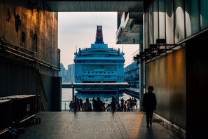 Een waterkantpromenade met een groot cruiseschip in de verte.