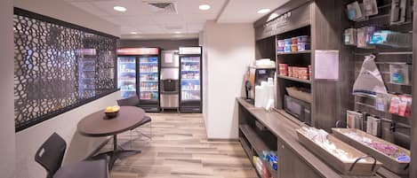 A coffee shop interior with a counter, seating area, and refrigerated display cases.