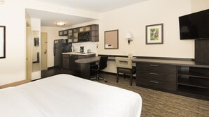 A hotel room with a bed, a desk, a chair, a TV, a microwave, and a refrigerator. - Candlewood Suites Ft Walton Bch - Hurlburt Area by IHG (Fort Walton Beach)