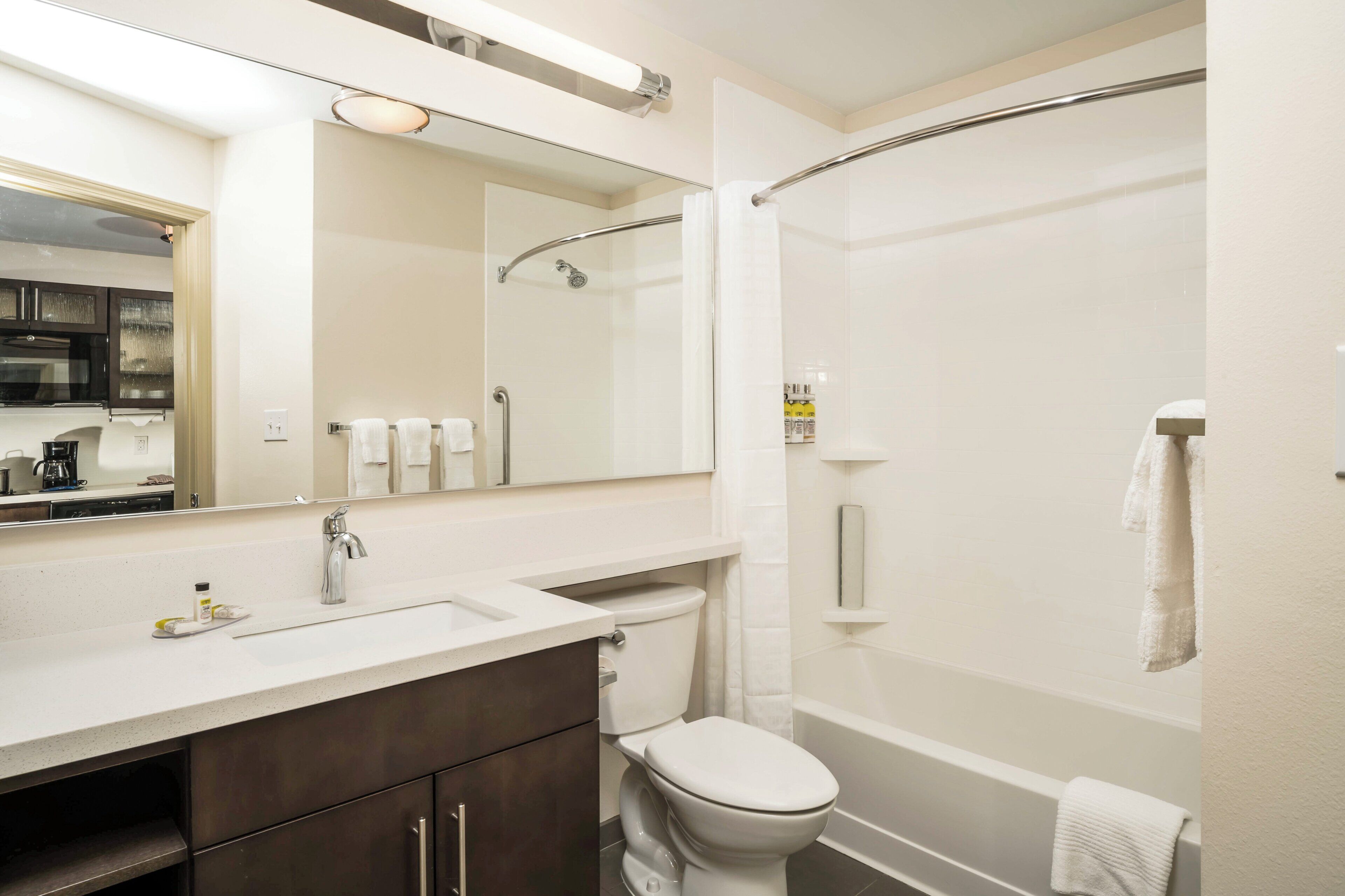 A modern bathroom with a shower, toilet, and sink.
