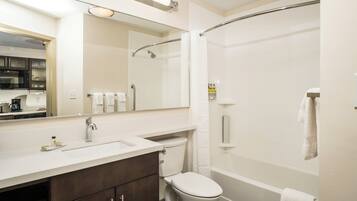 A modern bathroom with a shower, toilet, and sink.