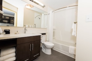 A modern bathroom with a toilet, sink, and shower. - Candlewood Suites Ft Walton Bch - Hurlburt Area by IHG (Fort Walton Beach)