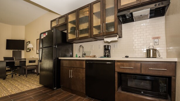A compact kitchen with a refrigerator, dishwasher, microwave, and a coffee maker. - Candlewood Suites Ft Walton Bch - Hurlburt Area by IHG (Fort Walton Beach)