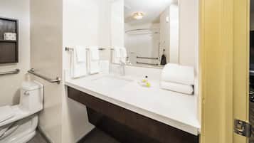 A modern bathroom with a white sink, a mirror, and a toilet.