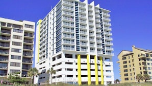 A multi-story hotel with balconies, a flat facade, and a clear sky. - Oceanfront  Seaside Resort 1403 3BR/3BA. Resort Amenities with Amazing views (NO. MYRTLE BEACH)