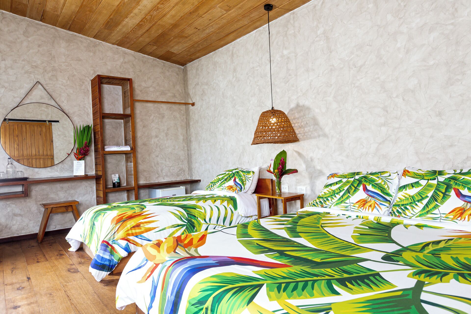 Un dormitorio con dos camas, una escalera de madera, una lámpara colgante y un estante con adornos.