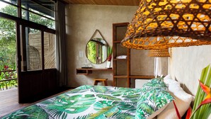 Une chambre à coucher avec un lit, un bureau en bois, un miroir et un luminaire suspendu.