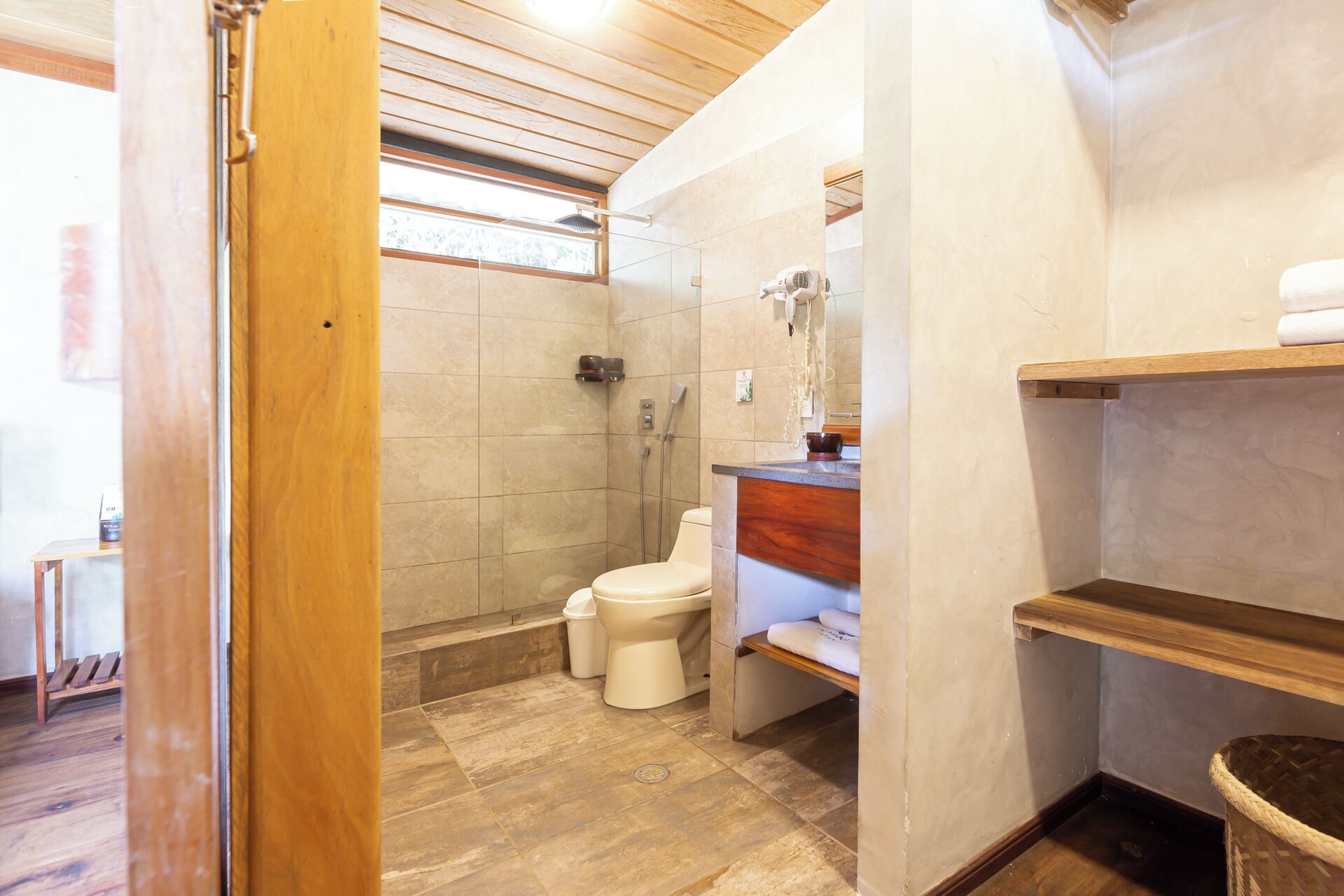 Une salle de bain avec douche, toilettes et lavabo.