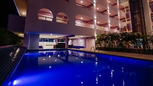 Un hotel moderno con una grande piscina interna, numerosi balconi e interni luminosi.