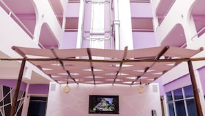 Un interno moderno con un'area reception, diversi piani e un atrio centrale.