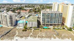 A coastal cityscape with high-rise buildings, a beach, and a clear sky. - Verandas 305- Oceanfront 3BR Condo-Oceanfront Pool- Walk to Main Street (NO. MYRTLE BEACH)