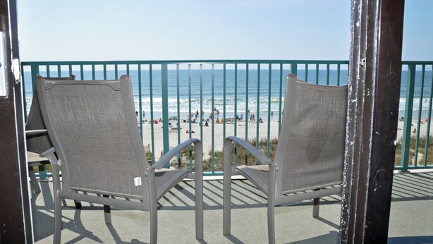 Two chairs facing a beach with a green railing. - Verandas 305- Oceanfront 3BR Condo-Oceanfront Pool- Walk to Main Street (NO. MYRTLE BEACH)