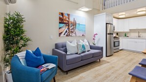 Un apartament modern amb saló, cuina i un balcó.