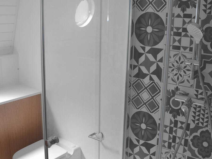 Een moderne badkamer met een douchecabine van glas, een toilet en een wastafel.