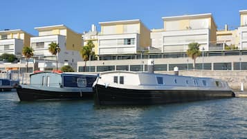 Two boats docked at a marina with buildings in the background.