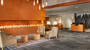A lobby with a reception desk, seating area, and a wall with candles.