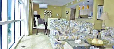 A living room with a sofa, chairs, a coffee table, and a dining area with a table and chairs.
