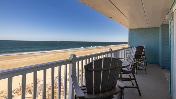 Ein Balkon mit Blick auf Strand und Meer.