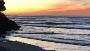Ein Strand mit Wellen bei Sonnenuntergang.
