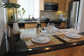 Enjoy cooking in this well-equipped kitchen with a stainless steel refrigerator, microwave, and sink.
