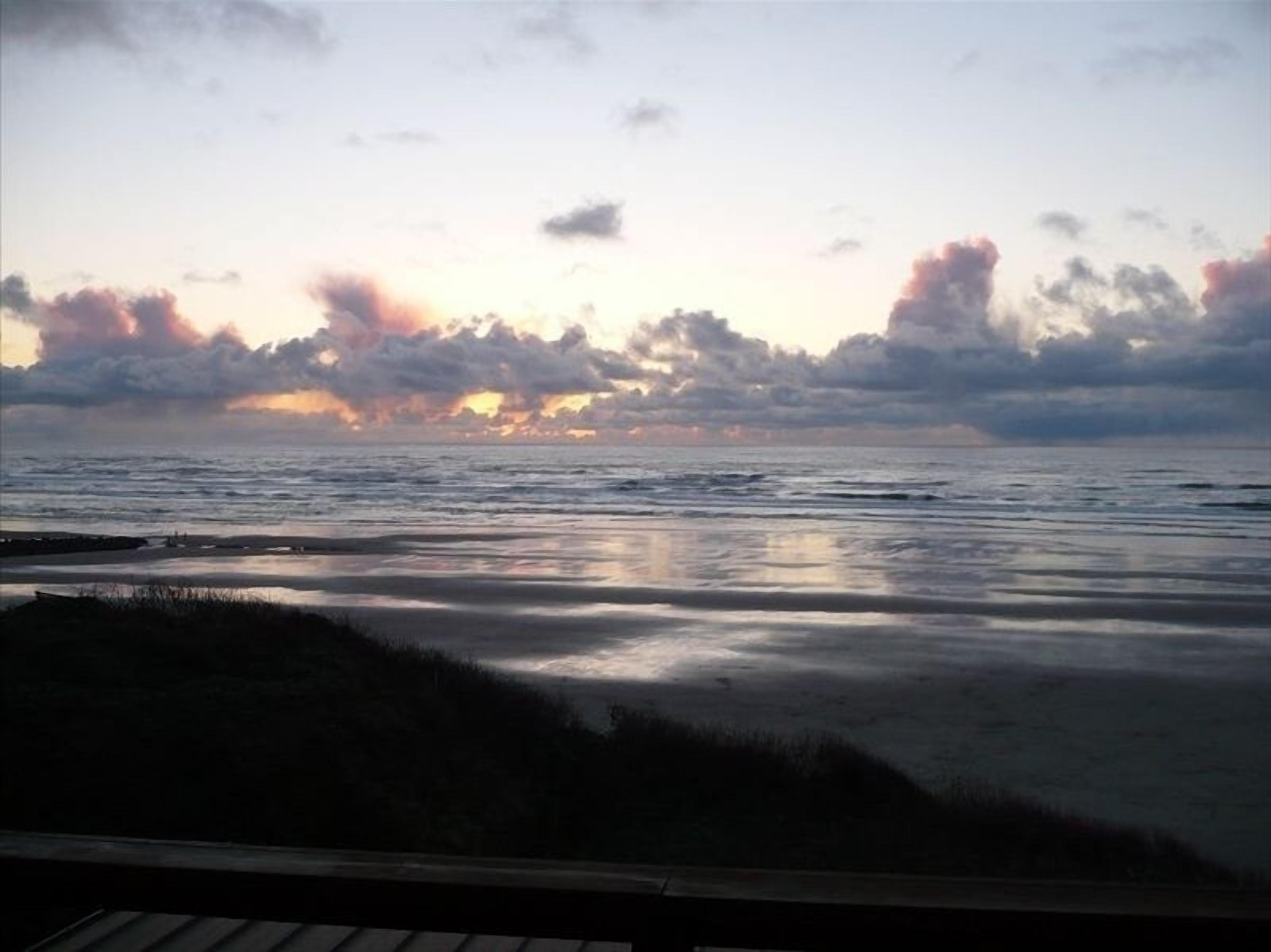 En strand med udsigt til havet og en overskyet himmel.