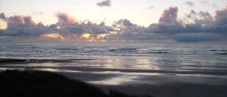 En strand med udsigt til havet og en overskyet himmel.