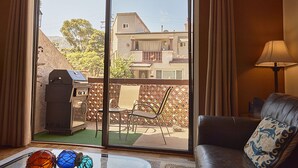 Ein Wohnzimmer mit einer Schiebetür zum Patio, einem Grill, einem Sofa und einer Lampe.
