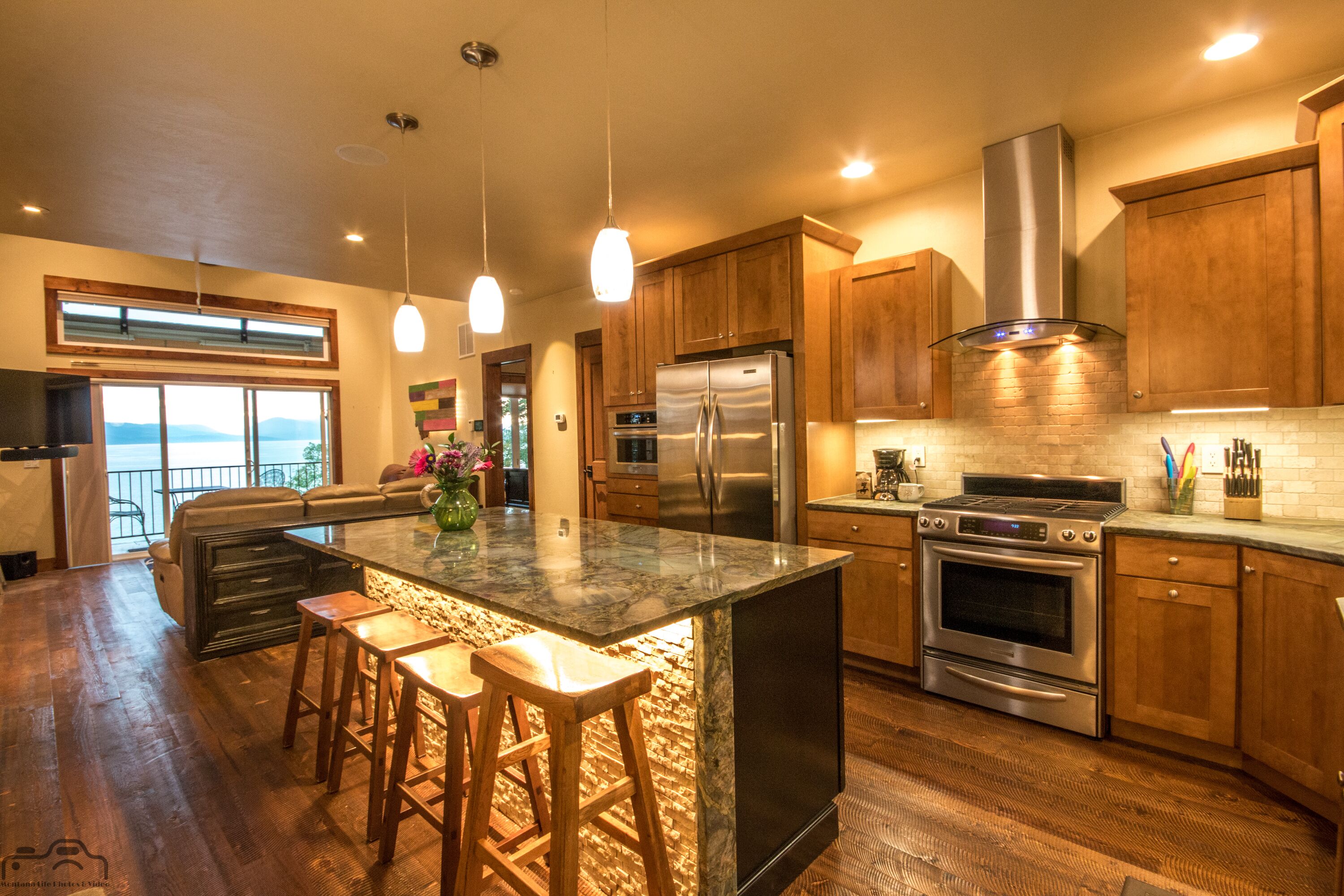 Kitchen looks to living room & lake. The entire house inside & out has speakers.