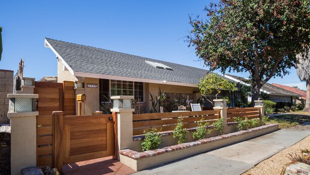 A residential property with a gated entrance, a covered patio, and a small garden area. - Huntington Beach Furnished Home,  Private Patio, Bikes, Parking & Putting Green (Huntington Beach)