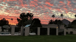 A residential area with a gated entrance, a swimming pool, and a mountain in the background. - Complete retreat with private hot tub. (Scottsdale)