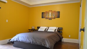 Ein Schlafzimmer mit einem Bett, einem Nachttisch und einem Wandbild.
