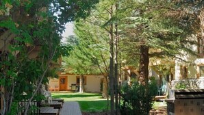 A pathway leading to a building with a covered outdoor seating area and a barbecue grill. - Great 1 (plus) bedroom condo. This is the best location in Ketchum! (Ketchum)