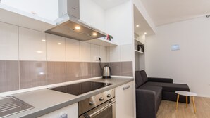 A modern kitchen with a built-in stove, oven, and a coffee maker on the counter.