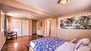A bedroom with a bed, a dresser, a chair, and a painting on the wall. - Cozy Colorado Springs Home Near Garden of the Gods (Colorado Springs)