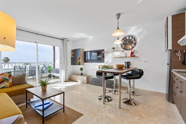 Un apartamento moderno con sala de estar, cocina y balcón.