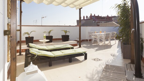 A rooftop terrace with a covered seating area, potted plants, and a table with chairs. - SUNNY ATTIC, 2 TERRACES, PRIVATE SOLARIUM, 3 ROOM, 2 BATHS. 3 MIN TO SUBWAY. (Barcelona)