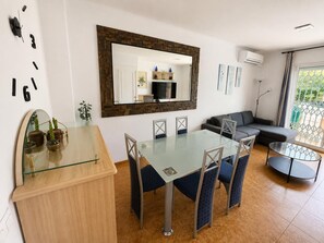 A modern living room with a glass dining table, a sofa, and a large mirror. - MAGNIFICENT CHALET, 5 NIMUTOS FROM THE BEACH, WITH POOL, TERRACE AND WIFI. (Miami Platja)
