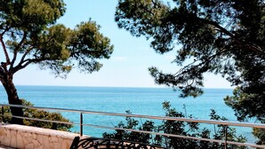 A bench with a metal frame and patterned seat, placed on a stone-paved area with a railing in the background. - MAGNIFICENT CHALET, 5 NIMUTOS FROM THE BEACH, WITH POOL, TERRACE AND WIFI. (Miami Platja)
