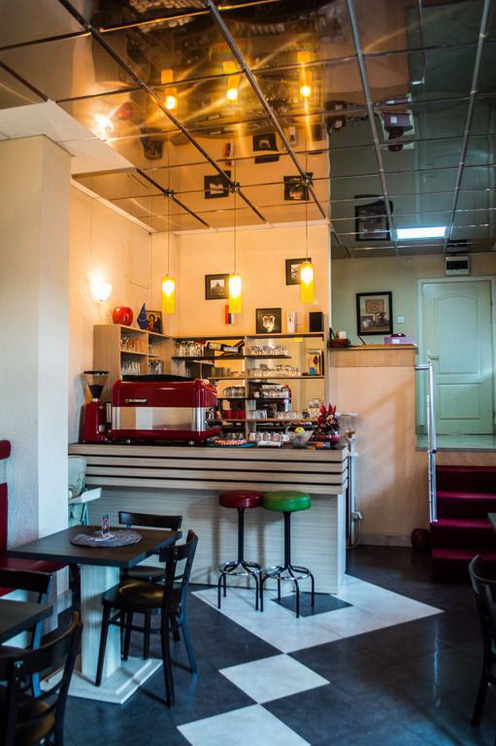 A restaurant with a bar area, seating, and a coffee machine.
