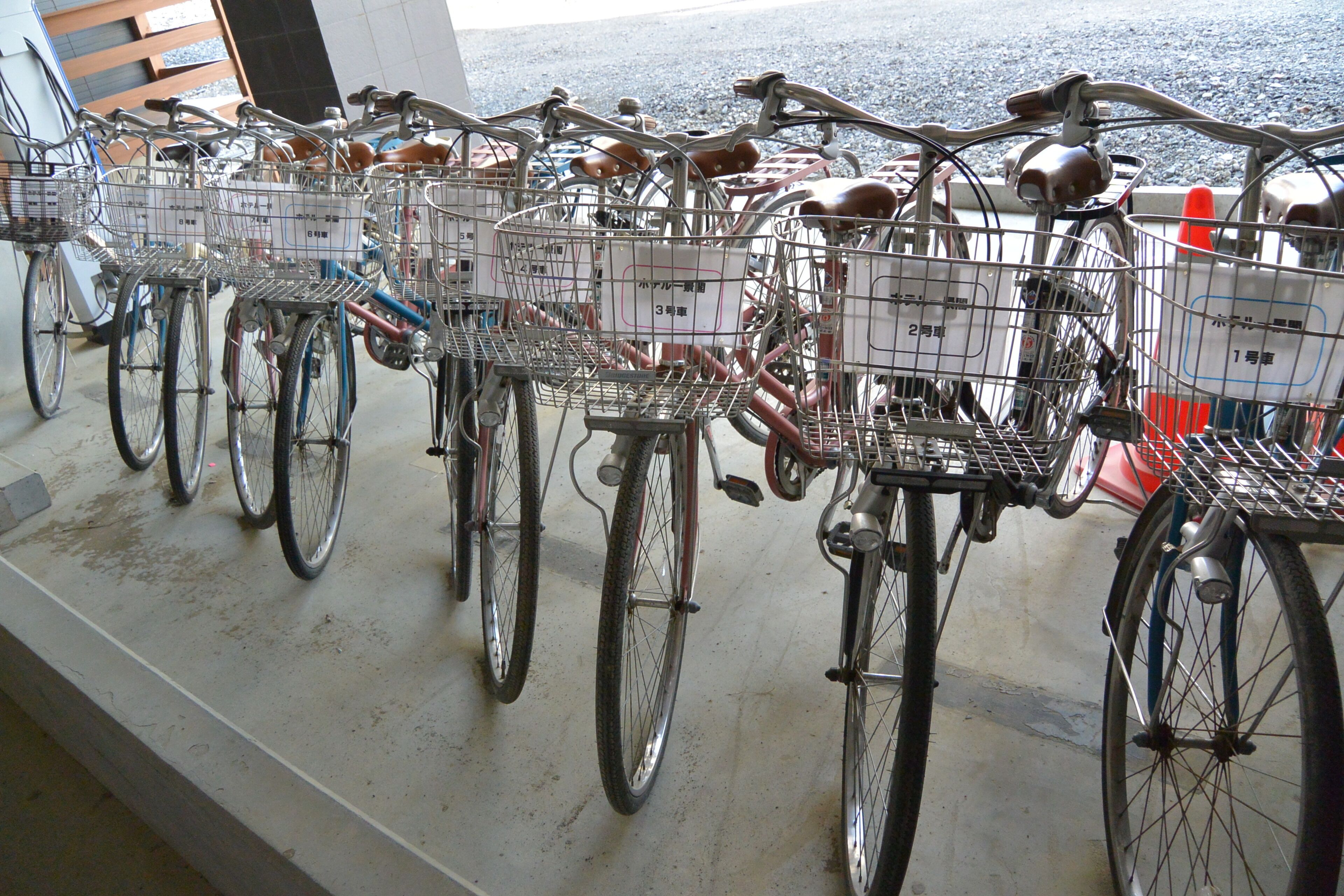Bicycles with baskets, parked in a row.