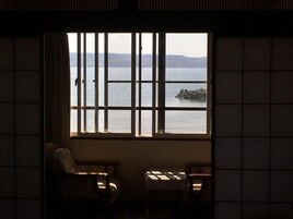 A room with a large window, a chair, and a table.