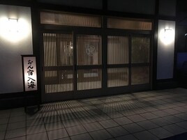 Un edificio japonés tradicional con suelo de baldosas y puerta corredera de madera.