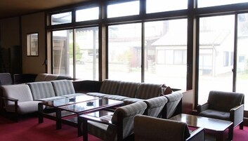 Una sala de estar con un juego de sofá, una mesa de centro y vistas amplias a través de ventanas grandes.
