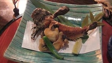 Un plato con mariscos, que incluye un pescado entero, camarones y una cuña de limón.