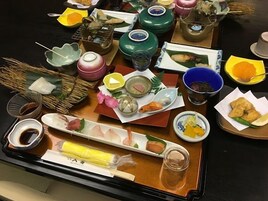 Variedad de platos y cubiertos sobre una mesa, sugiriendo un ambiente para comer.