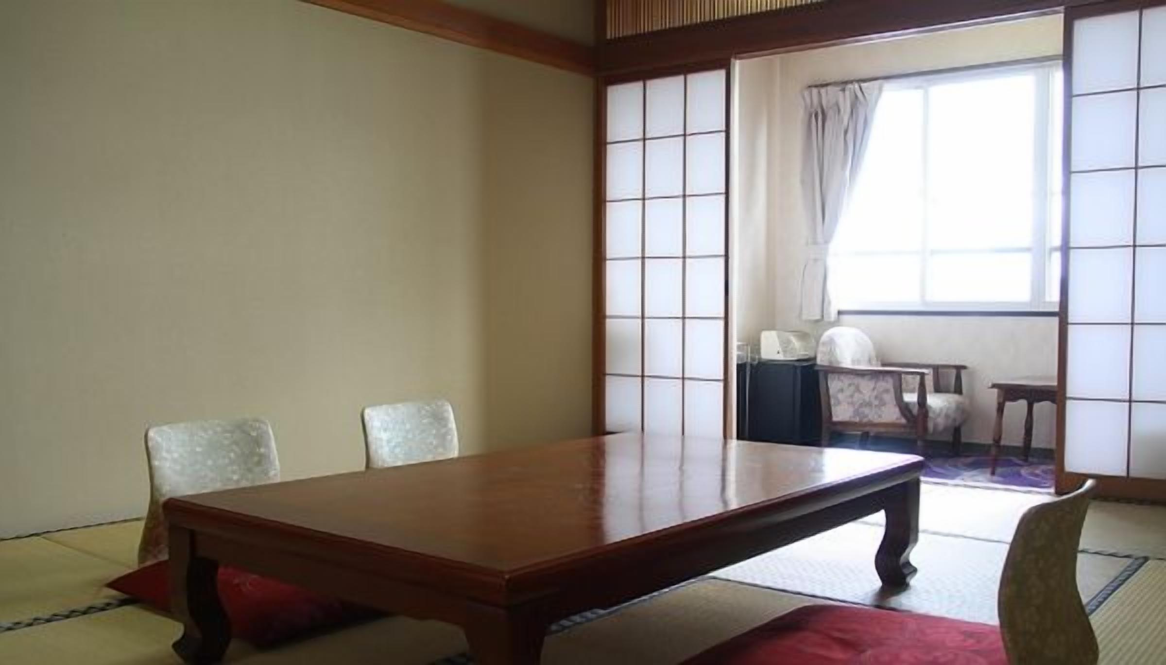 A traditional Japanese room with tatami flooring, a low wooden table, and a shoji screen.