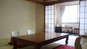A traditional Japanese room with tatami flooring, a low wooden table, and a shoji screen.