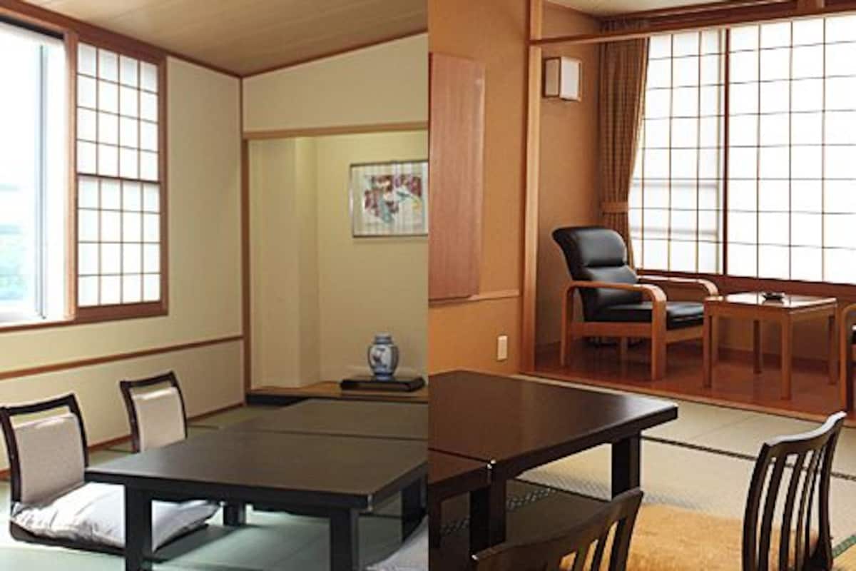 A traditional Japanese room with tatami flooring, a low table, and a sliding door.