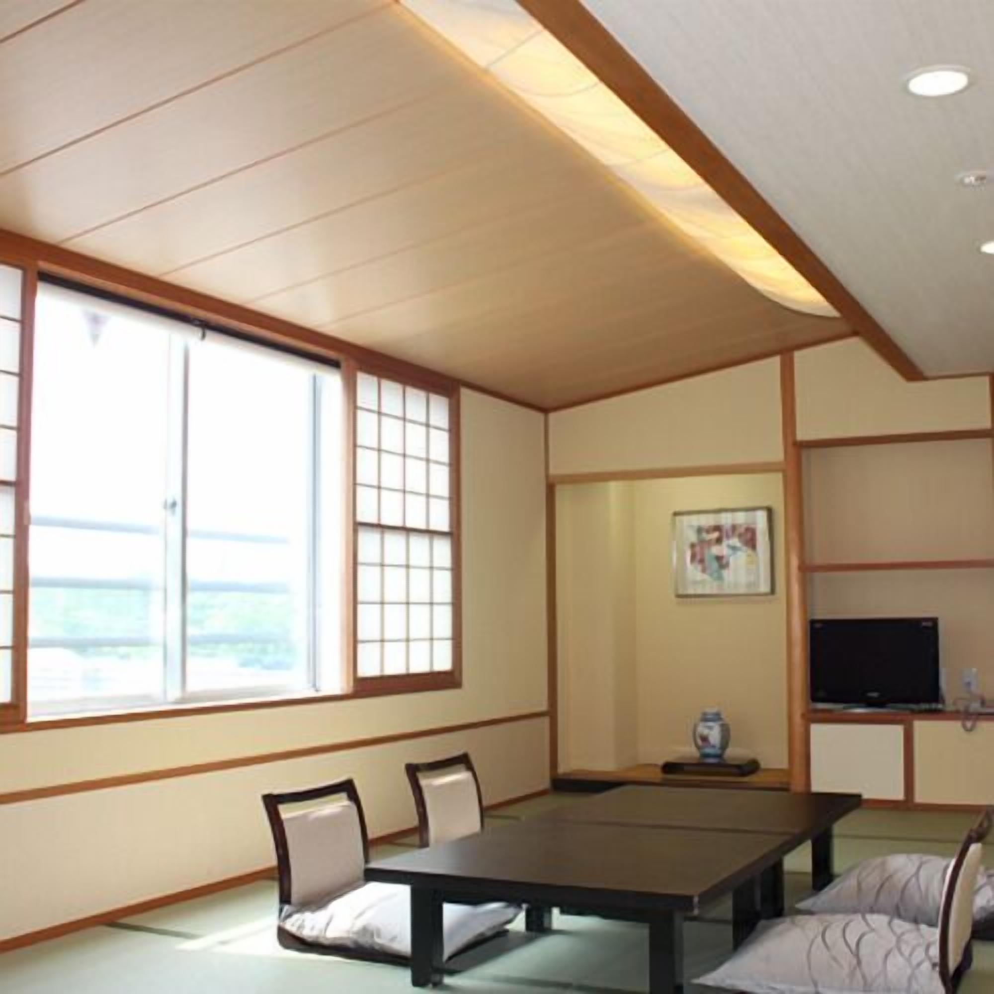 A traditional Japanese-style room with tatami flooring, a low table, and sliding doors.