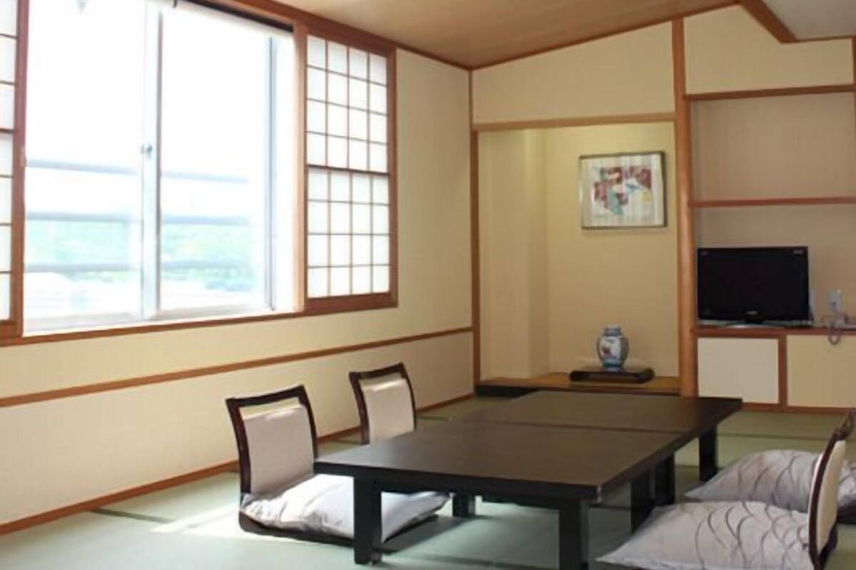 A traditional Japanese-style room with tatami flooring, a low table, and sliding doors.